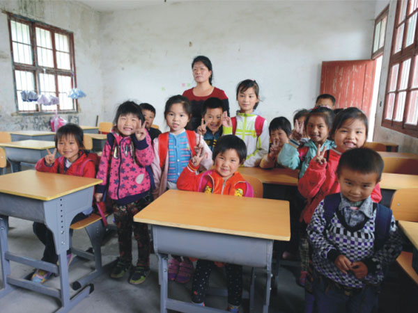 公司為一山村小學(xué)捐贈一批課桌椅，孩子們高興地和老師一起合影